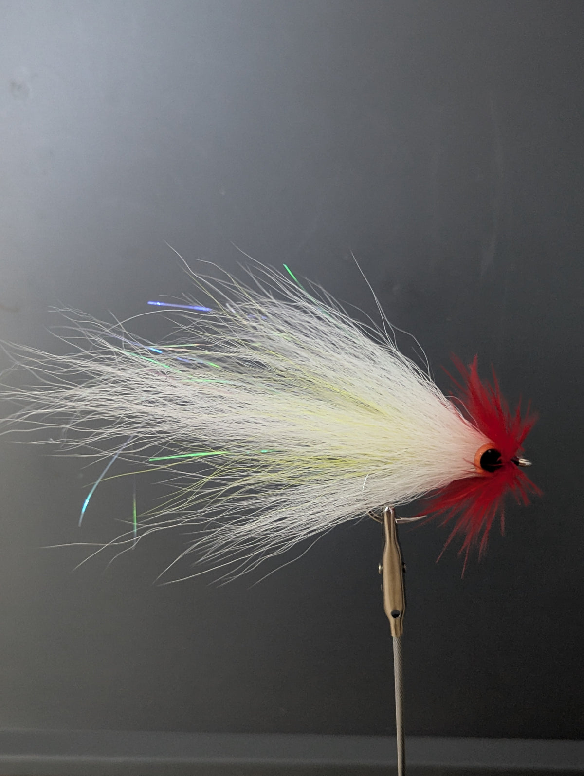 Fishing live scope fly with white and red details on a black background