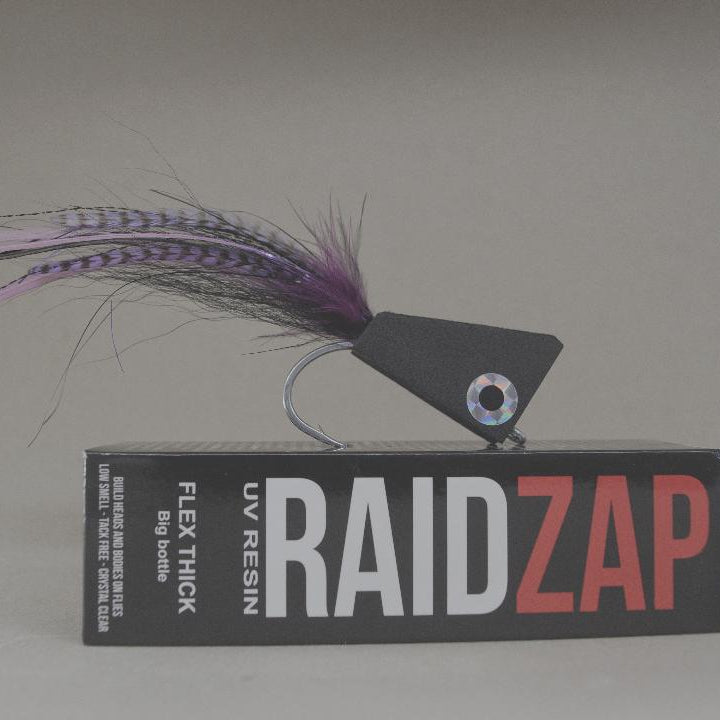 Fishing lure on top of a box labeled 'RAIDZAP' with a neutral background